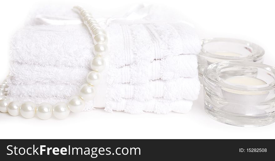Spa towels and candles on white background