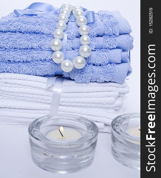 Spa towels and candles on blue background