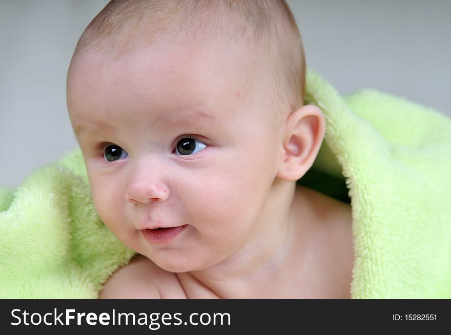 Cute little baby under green blanket