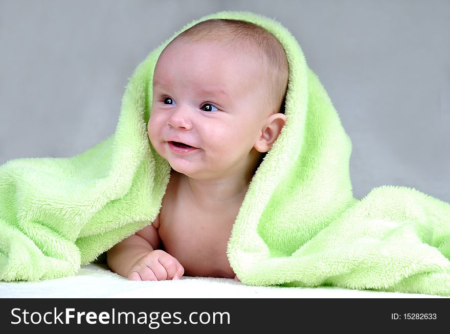 Cute little baby under green blanket