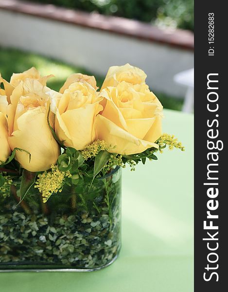 An arrangement of yellow roses in a vase. An arrangement of yellow roses in a vase