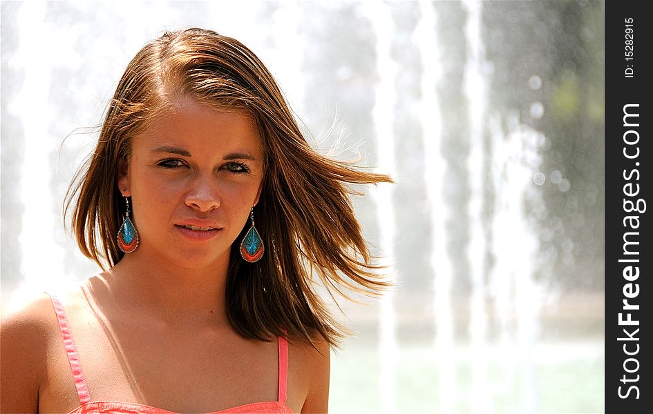 Teen girl standing by a fountain.