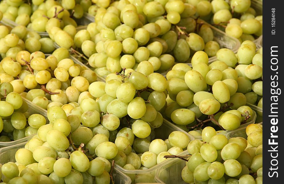 Fresh yellow grapes in baskets at market. Fresh yellow grapes in baskets at market