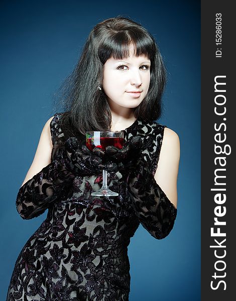 The beautiful girl in black dress with  red wine glass