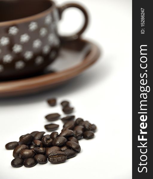Shallow focus on coffee beans with cup and saucer. Shallow focus on coffee beans with cup and saucer
