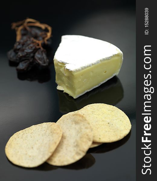 Brie cheese isolated on against a black background