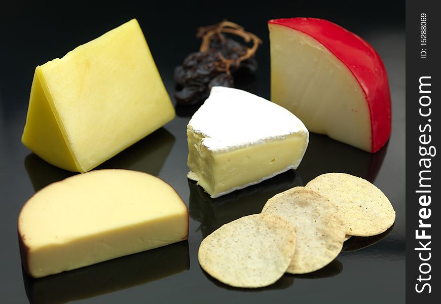 A selection of cheeses a black background. A selection of cheeses a black background