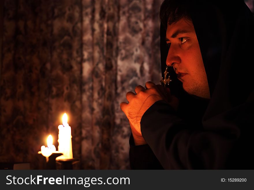 A man praying on a dark background