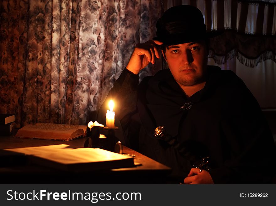 Man sitting by candlelight on a dark background