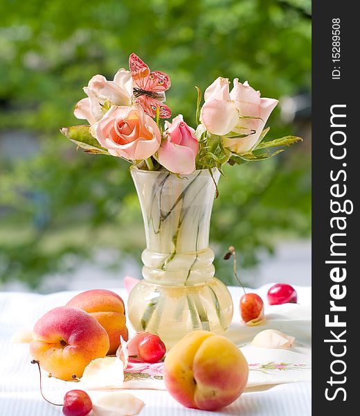 Roses in vase with butterfly and apricot on foreground