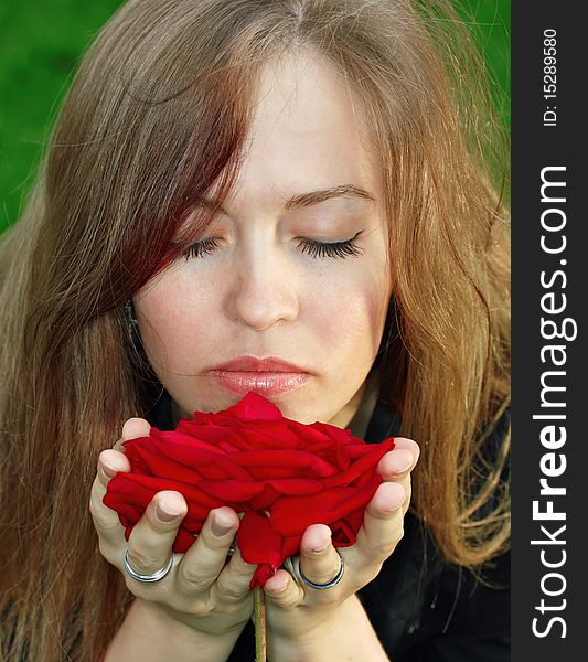 Young woman smelling red rose. Young woman smelling red rose