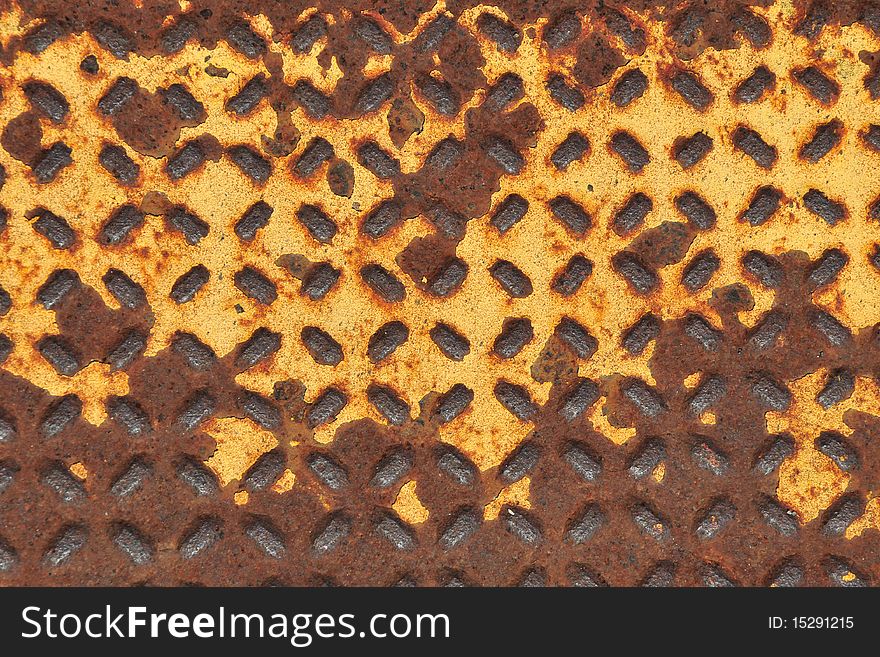 A rusty and yellow grate for walking to and from a place. A rusty and yellow grate for walking to and from a place.