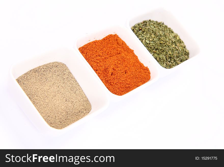 Spices in little bowls: dried parsley, pepper, paprika
