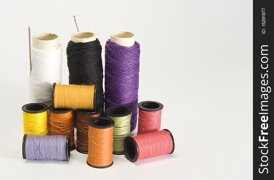 Spools of different color sewing threads.