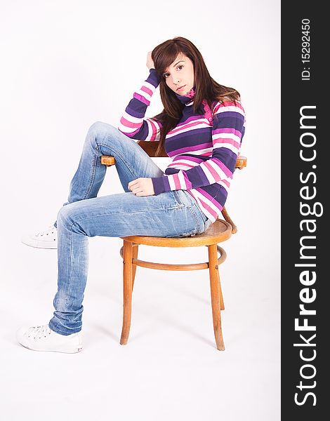 Beautiful teen girl sitting on wooden chair over white background