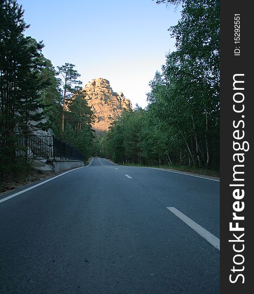 The road leading to the rock under clear sky. The road leading to the rock under clear sky