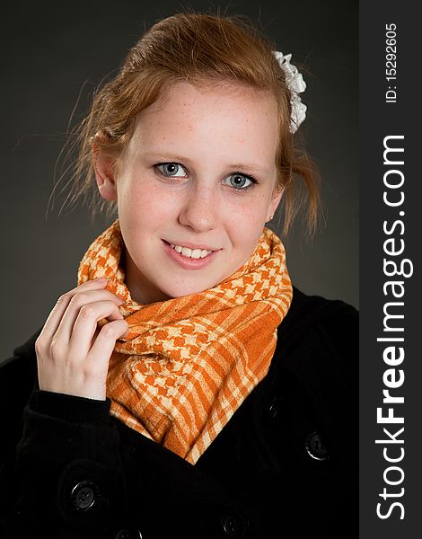Beautiful teen girl with scarf in front of dark green background