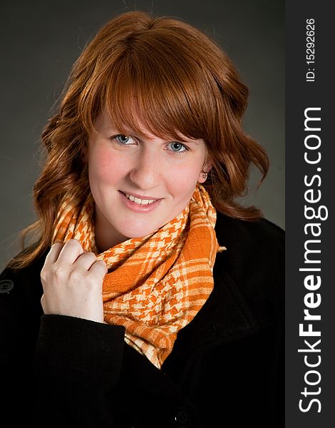 Beautiful teen girl with scarf in front of dark green background