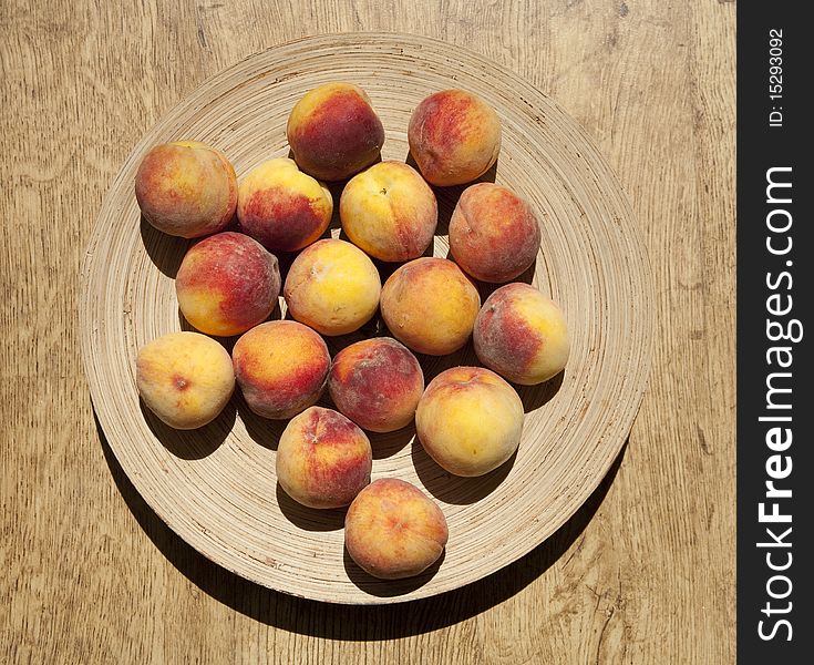 Ripe peaches on a round bamboo plate. Ripe peaches on a round bamboo plate