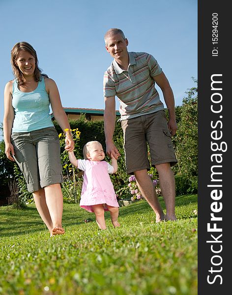 Young family walking in the garden of their home. Young family walking in the garden of their home