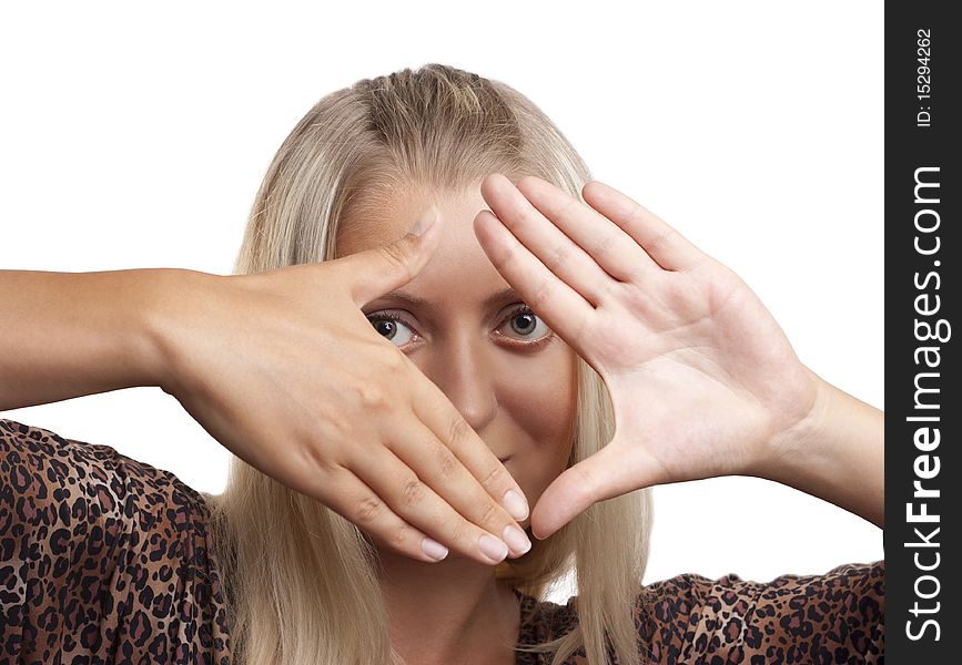 Pretty blonde girl looking through a frame made by her hands; isolated on white. Pretty blonde girl looking through a frame made by her hands; isolated on white