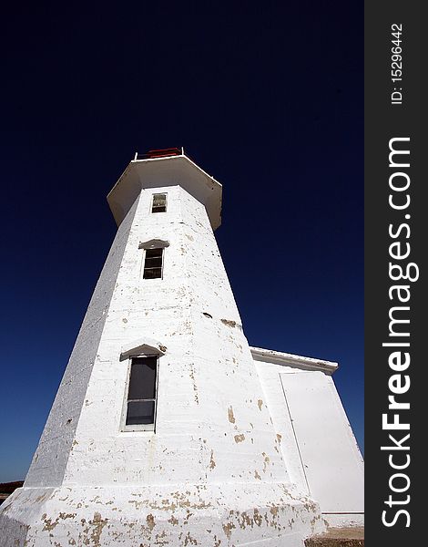 Wide angle base shot of the Peggy\'s Cove lighthouse, in Peggy\'s Cove, Nova Scotia. Wide angle base shot of the Peggy\'s Cove lighthouse, in Peggy\'s Cove, Nova Scotia