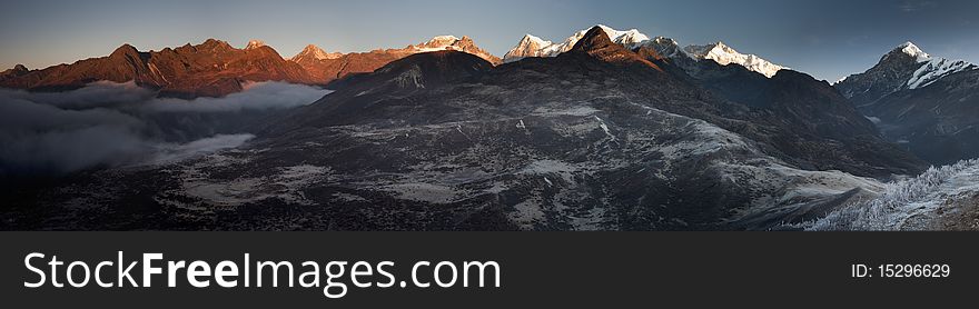 A panoramic perspective of the  Kanchenjunga Range captured during an early sunrise from a vantage point from Dzongri in Sikkim, India. A panoramic perspective of the  Kanchenjunga Range captured during an early sunrise from a vantage point from Dzongri in Sikkim, India.