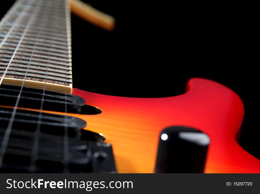 A six string electric guitar isolated on a black background