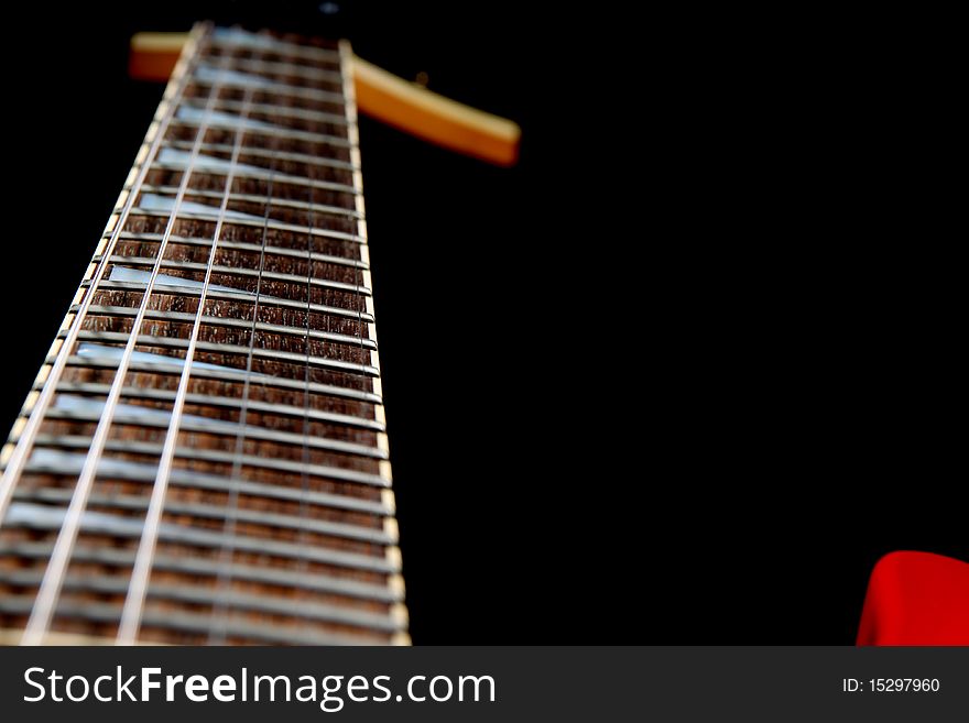 A six string electric guitar isolated on a black background