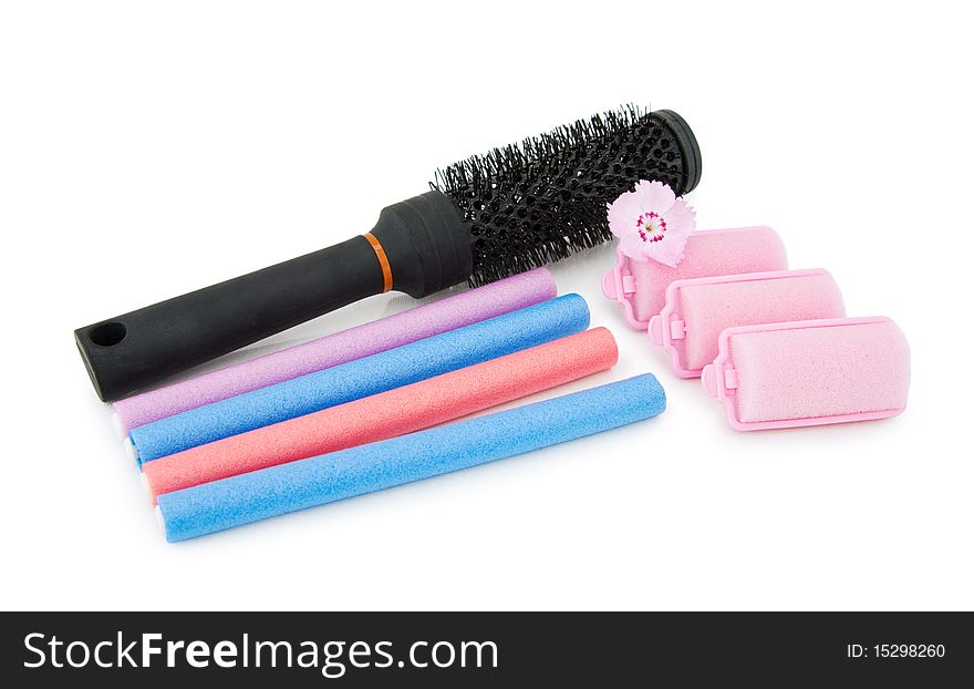 Hair brush and curlers on white