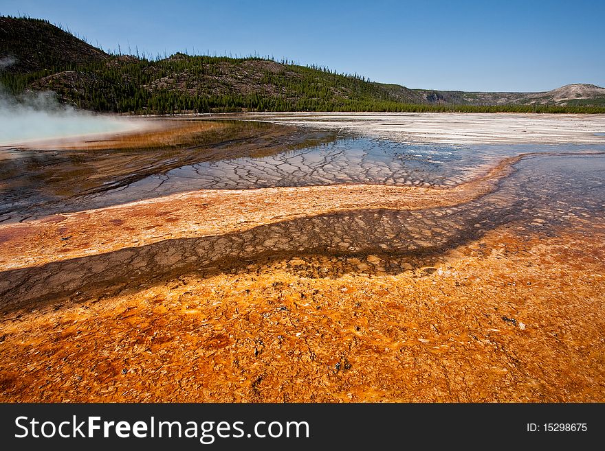 The microbial mat of bacteria and algae surrounding Grand Prismatic Spring at Midway Geyser Basin creates a colorful mosaic. The microbial mat of bacteria and algae surrounding Grand Prismatic Spring at Midway Geyser Basin creates a colorful mosaic.