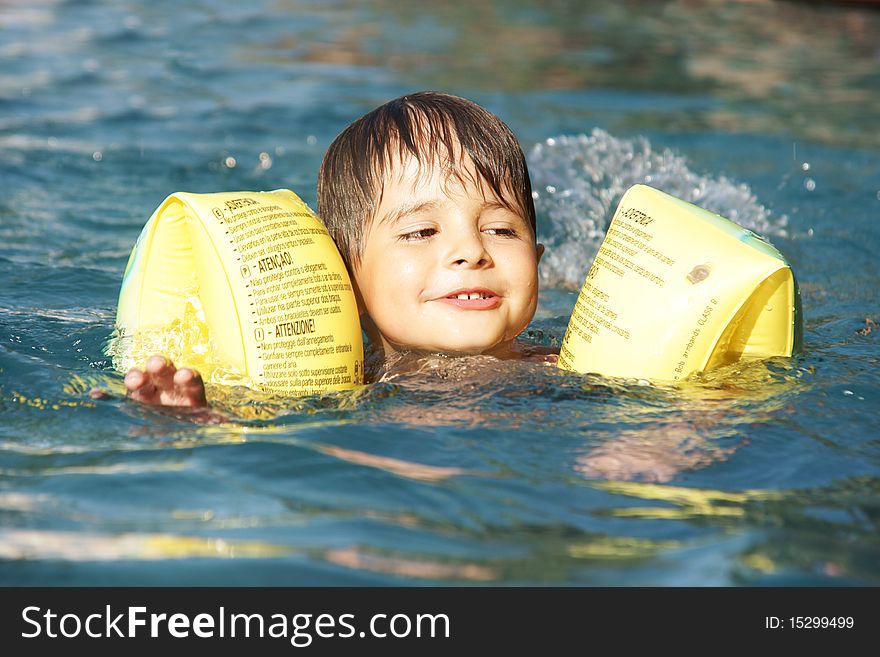 Happy smiling little boy swiming in pool, outdoor shot. Happy smiling little boy swiming in pool, outdoor shot