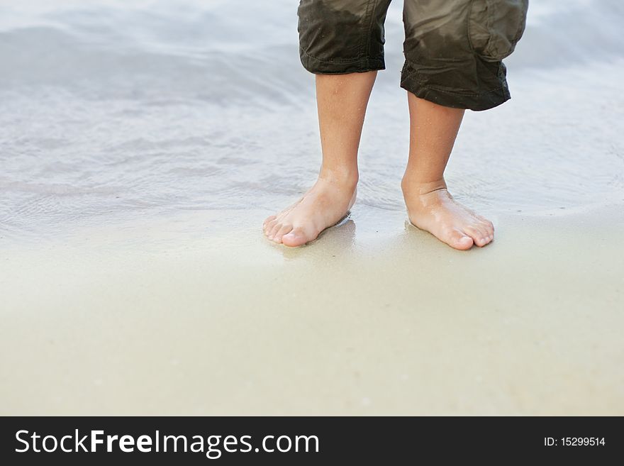 Little kid bare feet in the sea on beach. Little kid bare feet in the sea on beach