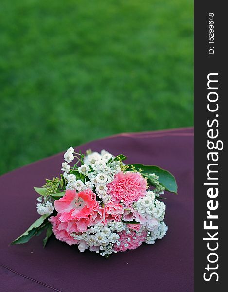 A bouquet of flowers resting on a table with grass copyspace above. A bouquet of flowers resting on a table with grass copyspace above.