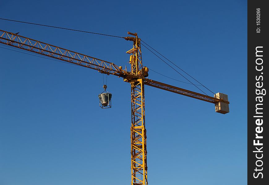 Yellow crane against blue sky