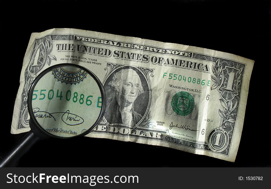 Magnifying glass over one dollar bill. Magnifying glass over one dollar bill