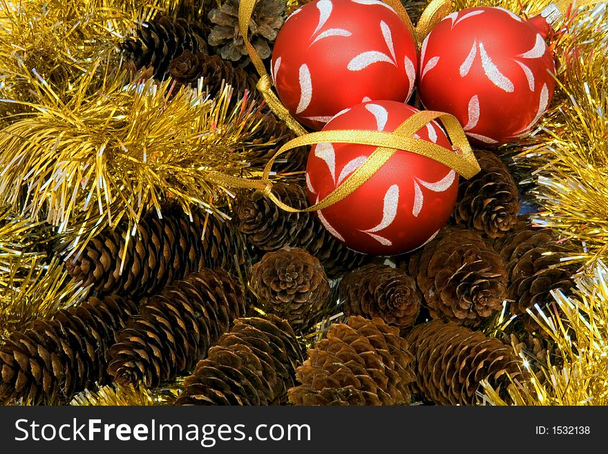 Christmas tinsel, three christmas balls, fir cones