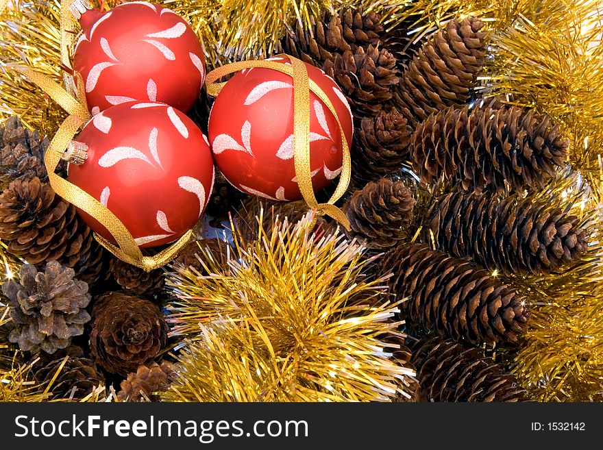 Christmas tinsel, three christmas balls, fir cones