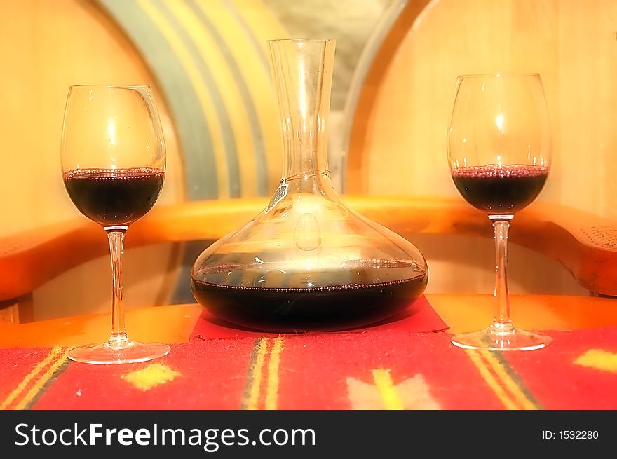 A composition of a bottle of red wine and glass with wine cellar in background. Soft filter added