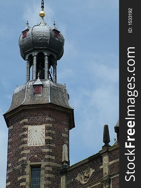 A clock tower with a sun-dial clock. A clock tower with a sun-dial clock