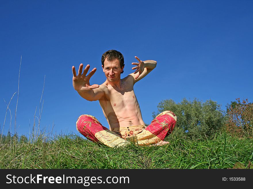Man making arms gestures sitting in park. Man making arms gestures sitting in park