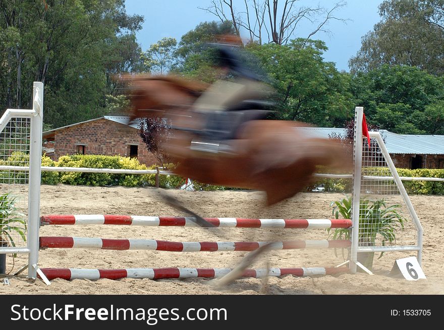 A horse jumping over an obstacle at a show jumping contest. A horse jumping over an obstacle at a show jumping contest.