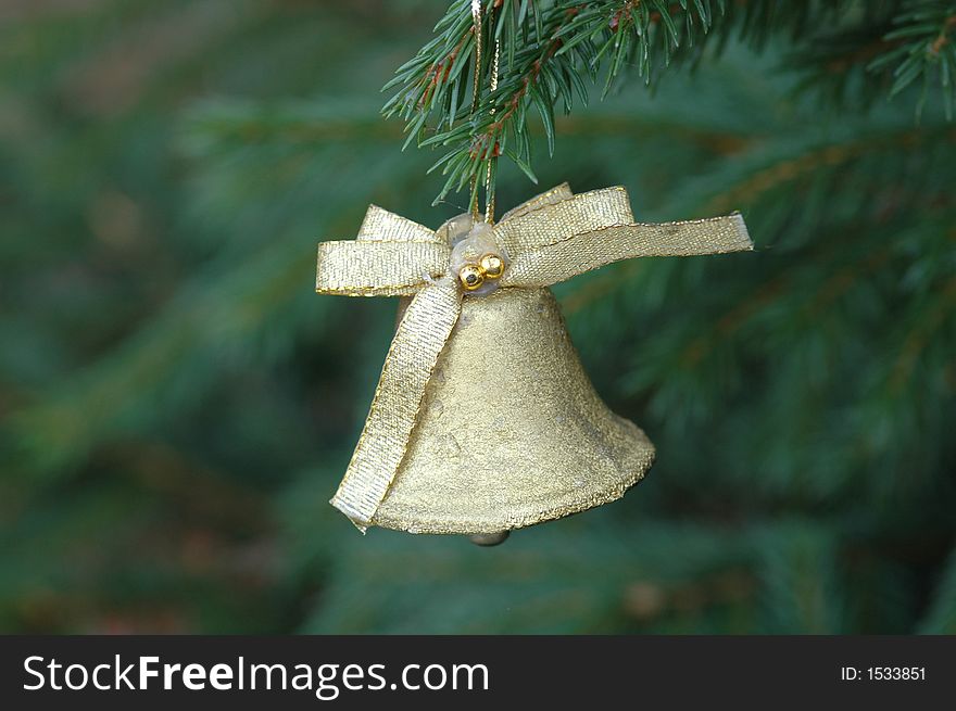 A golden bel hanging from branch