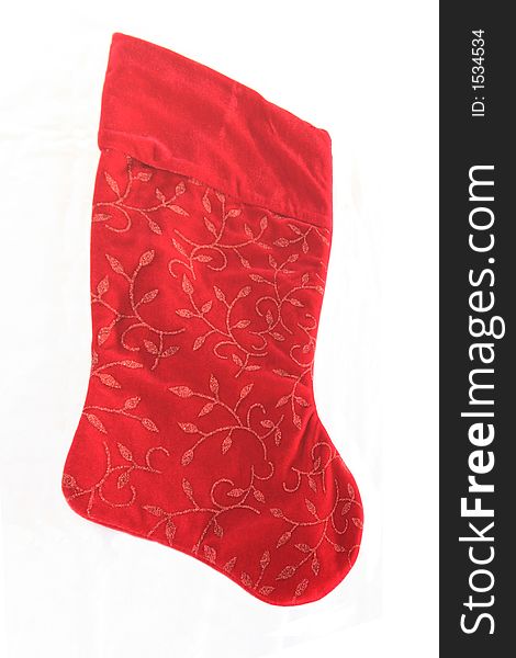 An isolated red Christmas stocking with a glitter design.