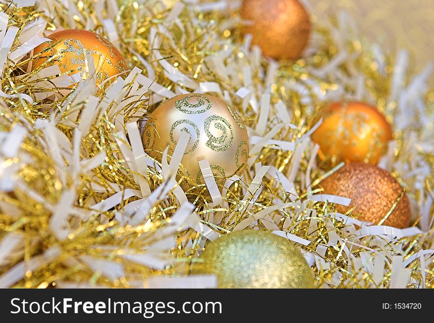 Christmas baubles nestled amongst gold & white tinsel. Christmas baubles nestled amongst gold & white tinsel