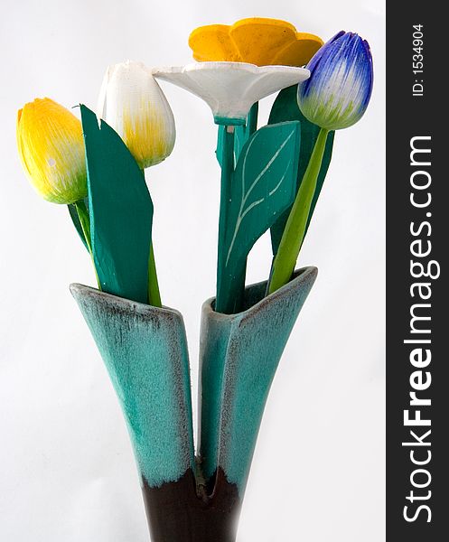 An arrangement of wooden flowers in a vase with card.