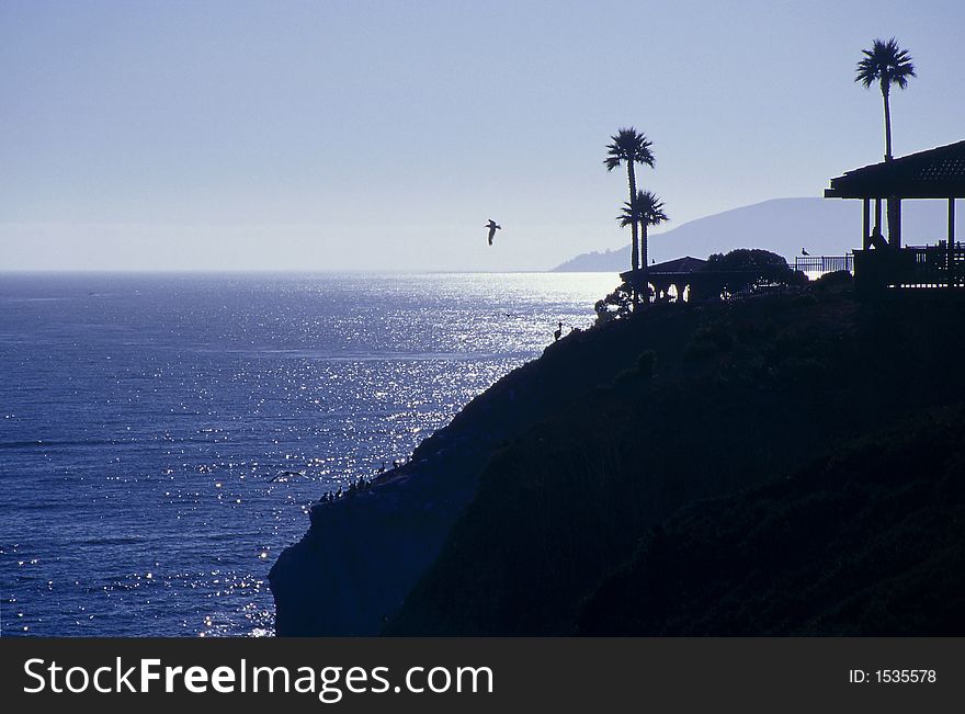 Silhouette of a tropical hut on a cliff overlooking the ocean. Silhouette of a tropical hut on a cliff overlooking the ocean.