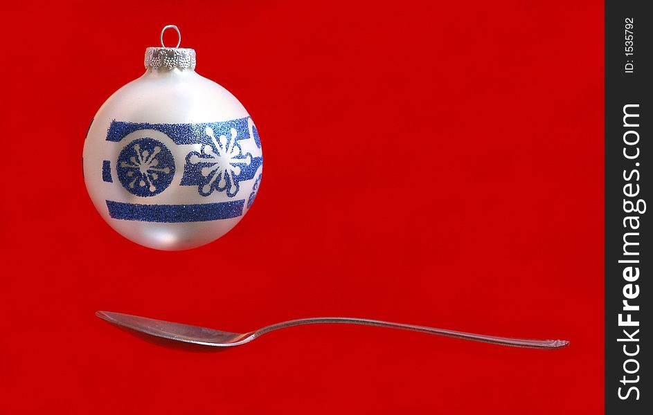A Christmas ornament over a spoon. A Christmas ornament over a spoon