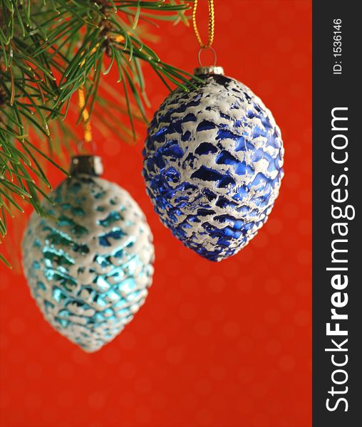 Two blue 1950s pinecone ornaments hanging from a christmas tree