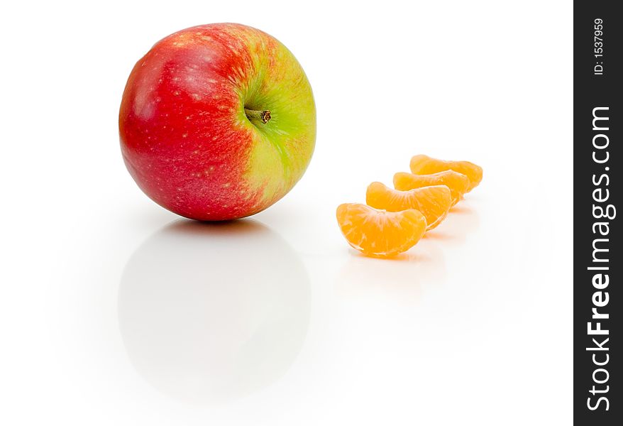 Composition made from apple and pieces of mandarins on isolated white background. Composition made from apple and pieces of mandarins on isolated white background